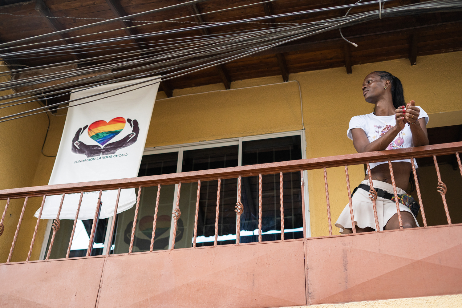 A woman leans against the balcony outside a second-floor office.