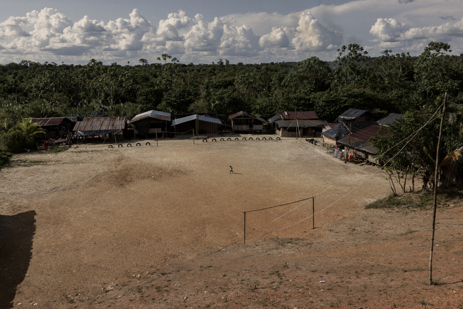 Un carré de terre et quelques maisons composent un village en lisière de jungle